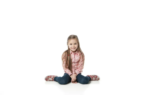 Hübsches kleines Mädchen sitzt in Jeans auf dem Boden — Stockfoto