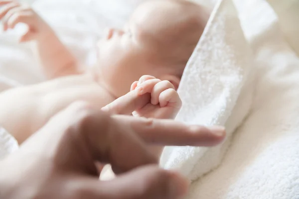 Bambino tenendo un dito del suo genitore — Foto Stock