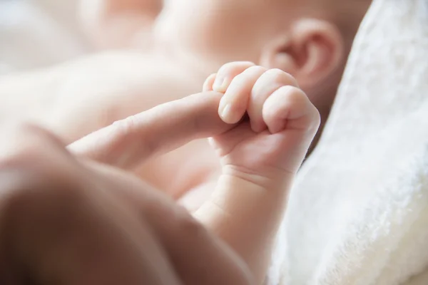Bambino tenendo un dito del suo primo piano genitore — Foto Stock