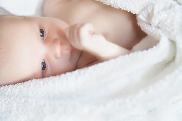 Новорожденный крошечный ребенок лежит на кровати вид сбоку — стоковое фото