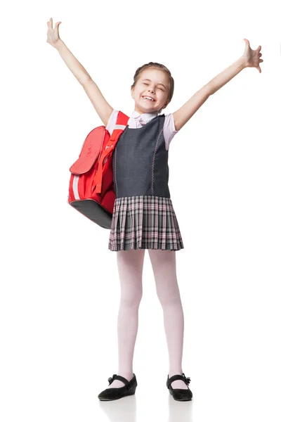 Glückliches kleines Schulmädchen in Uniform steht auf weißem Hintergrund — Stockfoto