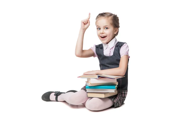 Bella bambina in uniforme scolastica con libri seduti sul pavimento — Foto Stock