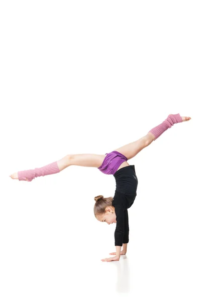 Söt liten tjej gör gymnastik över vit bakgrund — Stockfoto