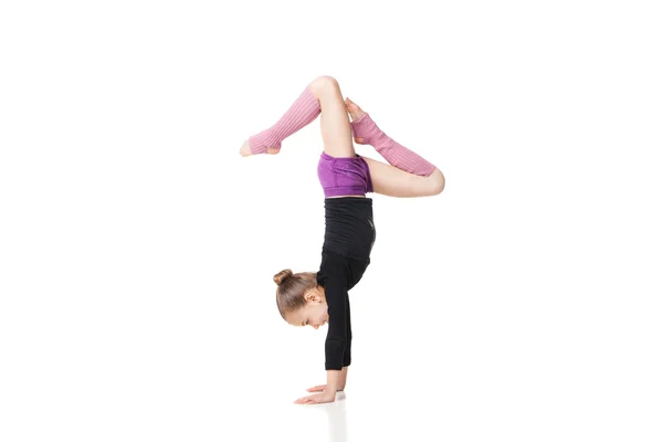 Pretty little girl doing gymnastics over white background — Stock Photo, Image