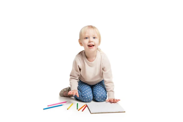 Kleines süßes Mädchen sitzt auf dem Boden und zeichnet mit bunten Bleistiften — Stockfoto