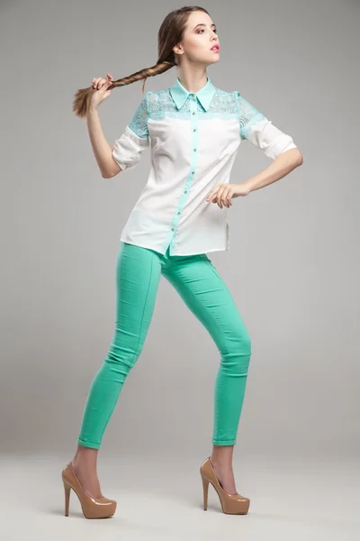 Mulher atraente em blusa branca e calças turquesa — Fotografia de Stock