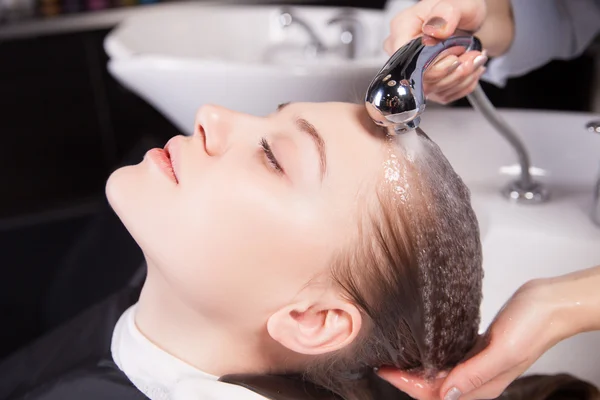 Parrucchiere lavare una donna capelli biondi — Foto Stock