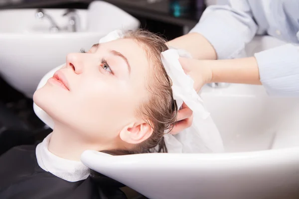 Stylist drying woman hair with towel in salon — Stock Photo, Image