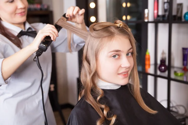 Lo stilista fa riccioli capelli in salone — Foto Stock