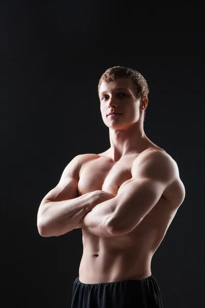 Gespierde jonge man toont de verschillende bewegingen en lichaamsdelen — Stockfoto
