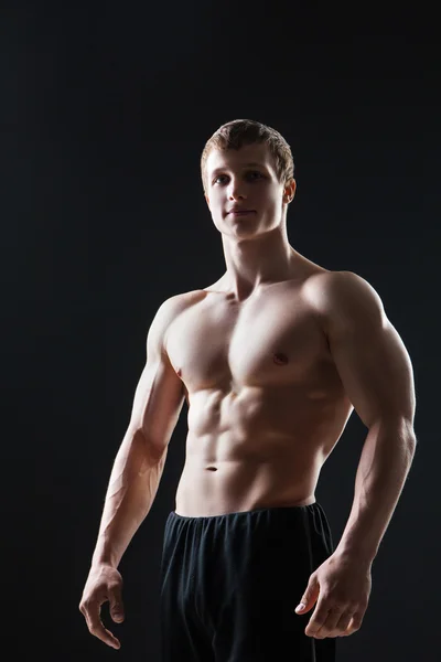 Hombre joven muscular muestra los diferentes movimientos y partes del cuerpo — Foto de Stock