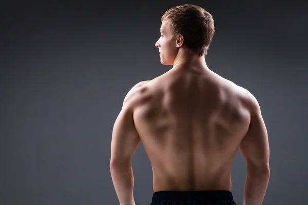 Widok z tyłu mięśni młody człowiek pokazuje różne ruchy i części ciała — Zdjęcie stockowe