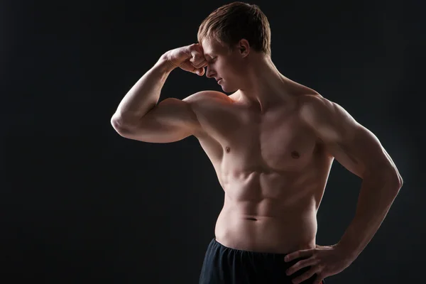 Muskulöser junger Mann zeigt die verschiedenen Bewegungen und Körperteile — Stockfoto