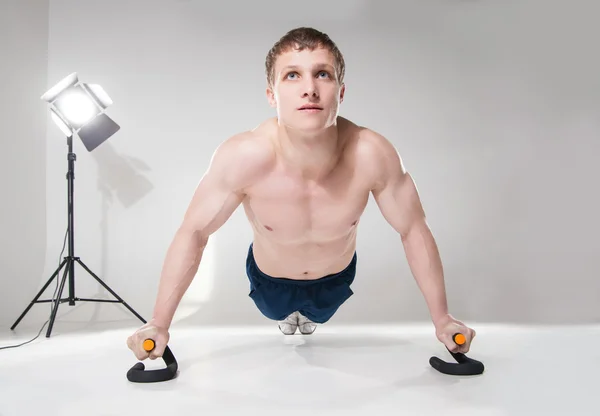 Muscular shirtless sportsman making push-ups  in studio — Stock Photo, Image