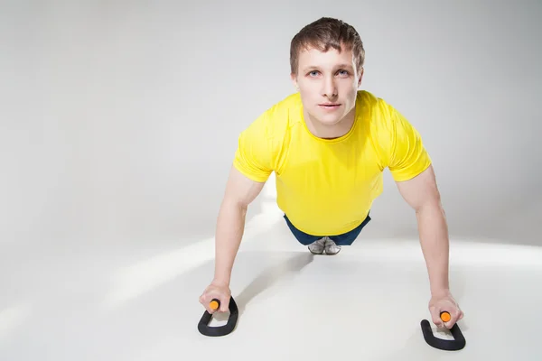 Musculoso deportista sin camisa haciendo flexiones en el estudio — Foto de Stock