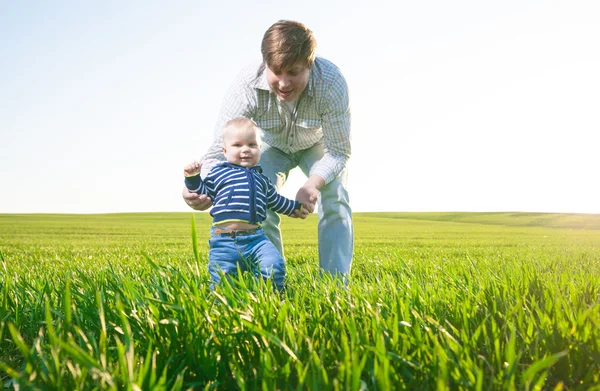 Giovane padre e suo figlio si divertono, giocando sul campo verde — Foto Stock