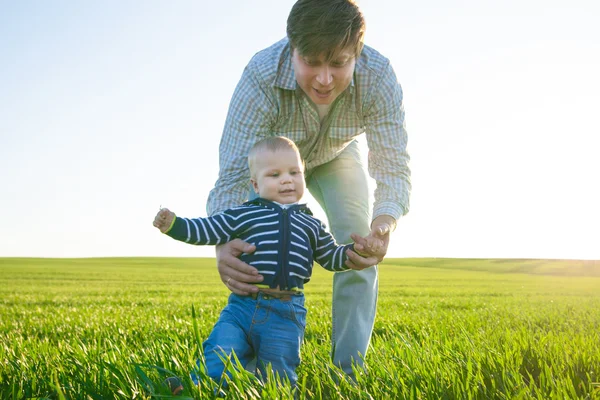 Unga far och hans son ha kul, spela på gröna fält — Stockfoto