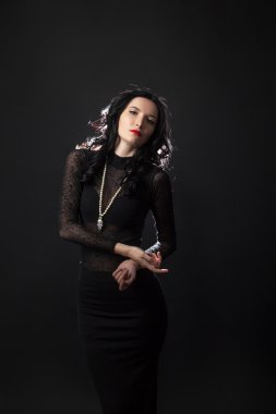 Şık bir gece elbisesi içindeki genç bayanın moda fotoğrafı.