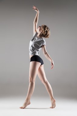young beautiful woman in grey T-shirt and black shorts dancing