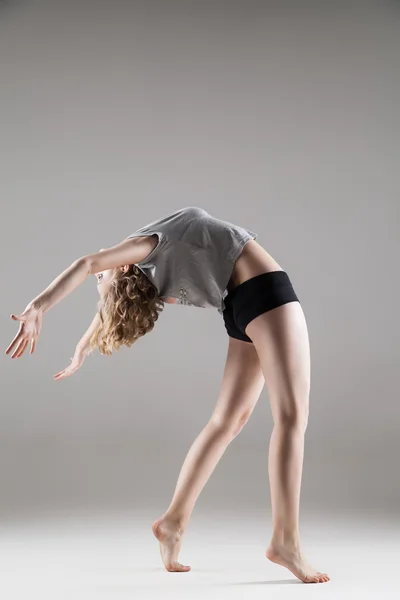 Young beautiful woman in grey T-shirt and black shorts dancing — Zdjęcie stockowe