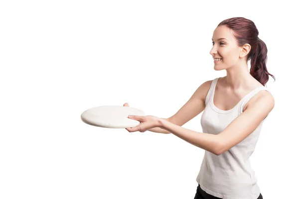 Молодая счастливая женщина, играющая фрисби над белыми — стоковое фото