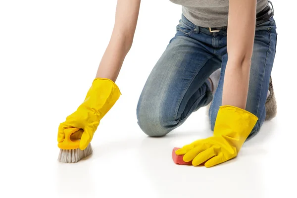 Vrouw in rubber glover met borstel reiniging van de vloer — Stockfoto