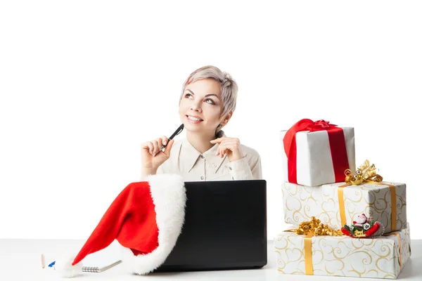 Señora en el escritorio con cajas de regalo y sombrero sobre blanco —  Fotos de Stock