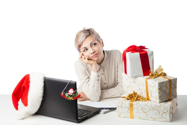 Señora en el escritorio con cajas de regalo y sombrero sobre blanco — Foto de Stock