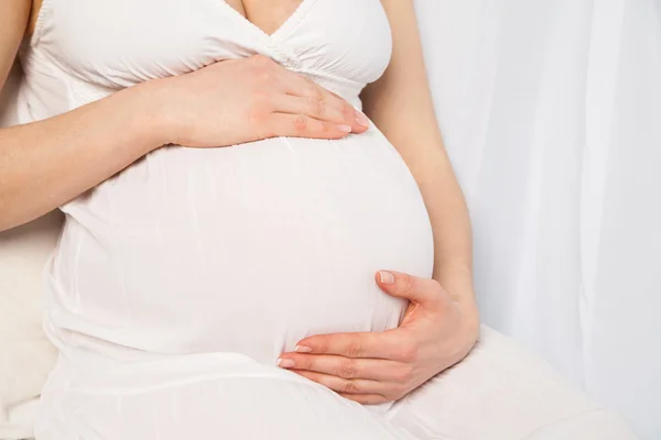 Niedliche schwangere Frau im Kleid über weißem Hintergrund — Stockfoto