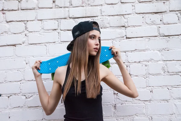 Schöne Mädchen in kurzen Hosen posiert über Mauer — Stockfoto