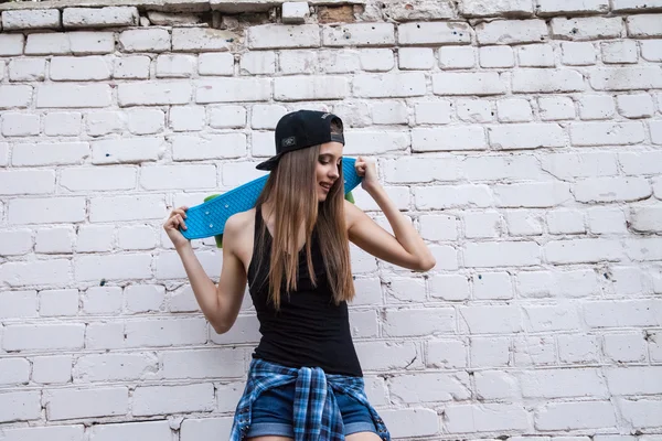 Hermosa chica en pantalones cortos posa sobre la pared de ladrillo — Foto de Stock