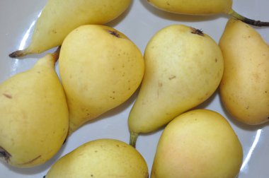 Masadaki küçük sarı armutlar