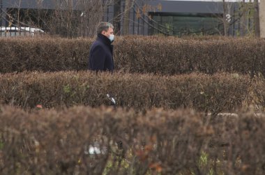 6 Kasım 2020, Rusya, Magnitogorsk. Koruyucu tıbbi maskeli bir adam şehir meydanında kuru çalıların arasında yürüyor. Yalnızlık ve salgın hastalıklar. İade. 