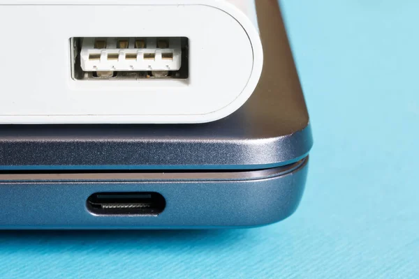 Comparison of the sizes of USB type-c and USB 3.0 ports on a modern laptop - ultrabook and an additional dongle on a blue background. Close-up. Macro