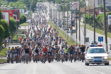25 Mayıs 2014, Rusya, Magnitogorsk. Şehir Bulvarı 'nda büyük bir bisiklet gezisine katılanlar. Polis arabası eskortu 