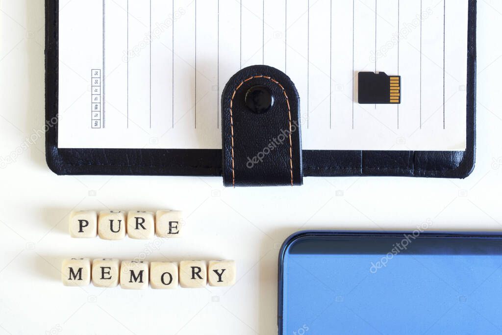Micro SD memory card with an open notebook and a blue smartphone next to the inscription: Pure memory. Miniaturization. Modern digital technologies and storage of memory. White background 