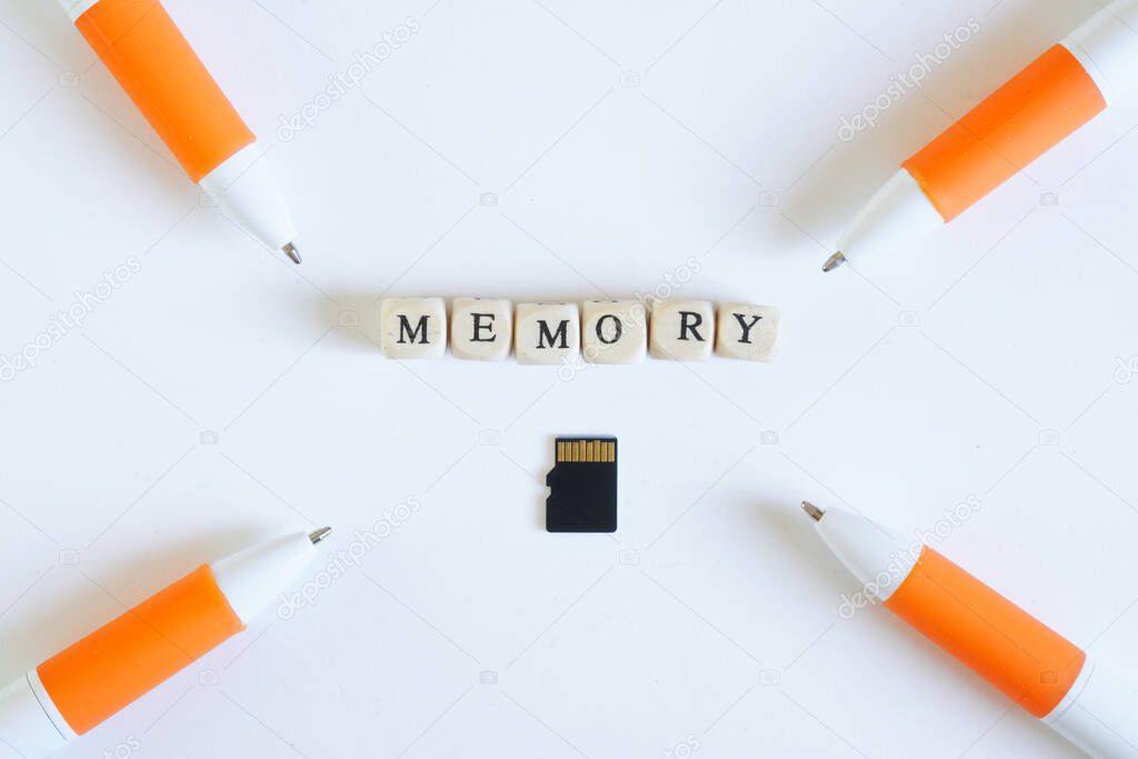 Micro-SD memory card on a white background next to a fountain pen. The problem of learning and memorizing material. Close-up