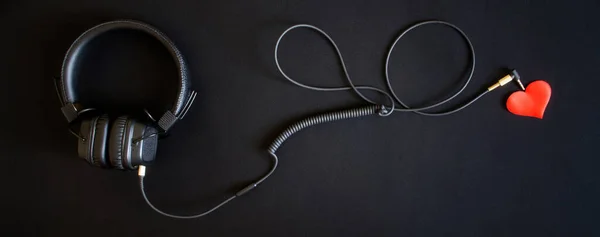 黒い背景に有線ヘッドフォンと赤いハート 音楽による感情 バナー — ストック写真