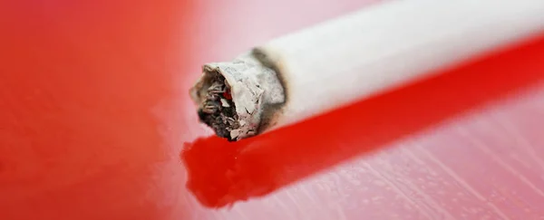 Cigarrillo Inextinguible Yace Sobre Una Superficie Roja Peligro Fuego Macro — Foto de Stock