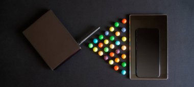 Akıllı telefon, tablet, siyah yönlendirici ve koyu arkaplanda çok renkli toplar. Kablosuz veri iletim sembolü. Yukarıdan görüntüle. 