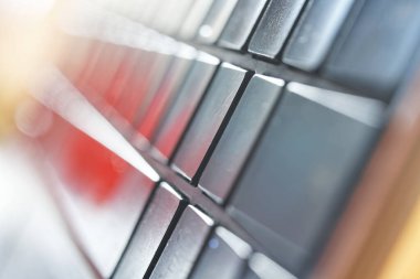 Işık, modern gümüş bir dizüstü bilgisayarın ince klavyesi, alışılmadık bir açıdan çekilmiş. Teknolojik soyutlama. Makro. Bokeh. Seçici odaklanma. Yakın plan.