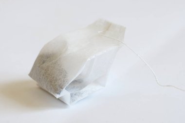 Beyaz masada yeni bir siyah çay poşeti var. Bir yazı için boş yer. Makro. Yakın plan..