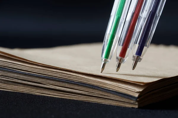 Πράσινο Κόκκινο Και Μπλε Στυλό Δίπλα Ένα Οικολογικό Ανακυκλωμένο Σημειωματάριο — Φωτογραφία Αρχείου