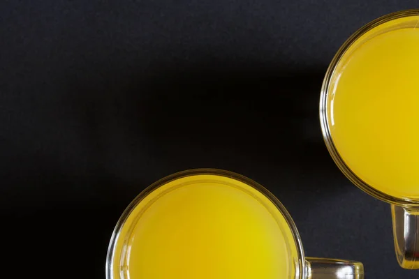 装有橙汁 菠萝汁或芒果汁的玻璃杯放在深色的表面上 从上面看供登记的空余空间 后续行动 — 图库照片