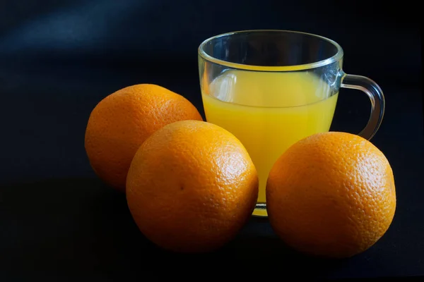 Μια Διάφανη Γυάλινη Κούπα Γεμάτη Χυμό Πορτοκαλιού Και Τρία Φρέσκα — Φωτογραφία Αρχείου