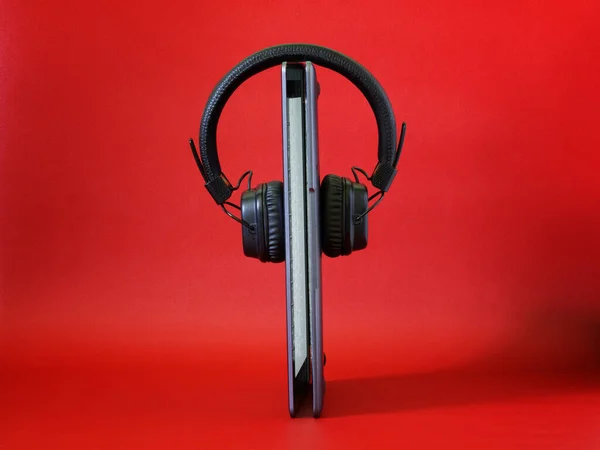 Glowing Laptop Stands Headphones Bright Red Background Concept Listening Music — Stock Photo, Image