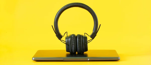 Closed Silver Laptop Black Wireless Headphones Bright Yellow Background Concept — Stock Photo, Image