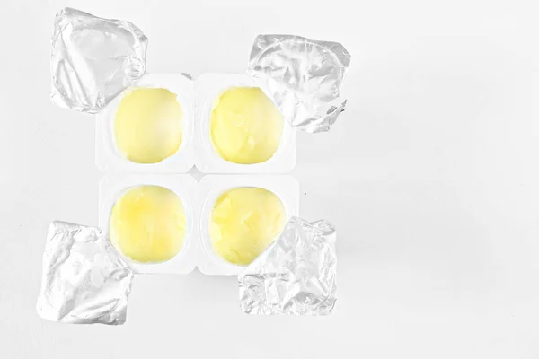 Τέσσερα Ανοιχτά Βάζα Γιαούρτι Πλαστική Και Αλουμινένια Συσκευασία Λευκό Φόντο — Φωτογραφία Αρχείου