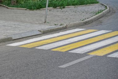 An example of a curb with an equipped wheelchair ramp and exit to a pedestrian crossing. Accessible urban environment. Daylight
