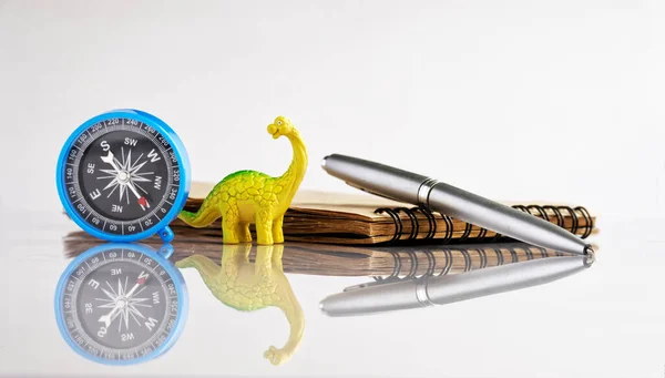 Компас Ручка Фонтану Блокнот Поруч Смішним Іграшковим Динозавром Диплодоком Білий — стокове фото